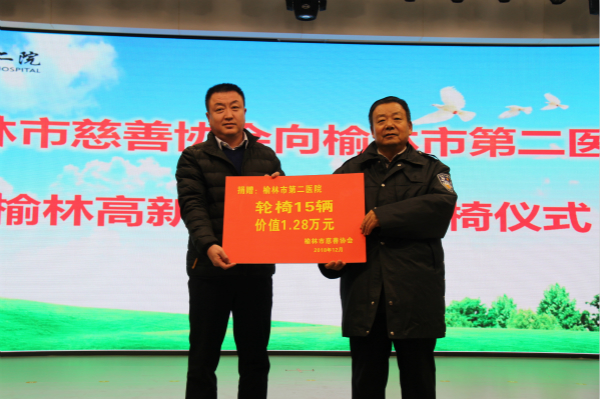 榆林市慈善协会副会长兼秘书长钟开有（右）向榆林二院递交捐赠牌.jpg
